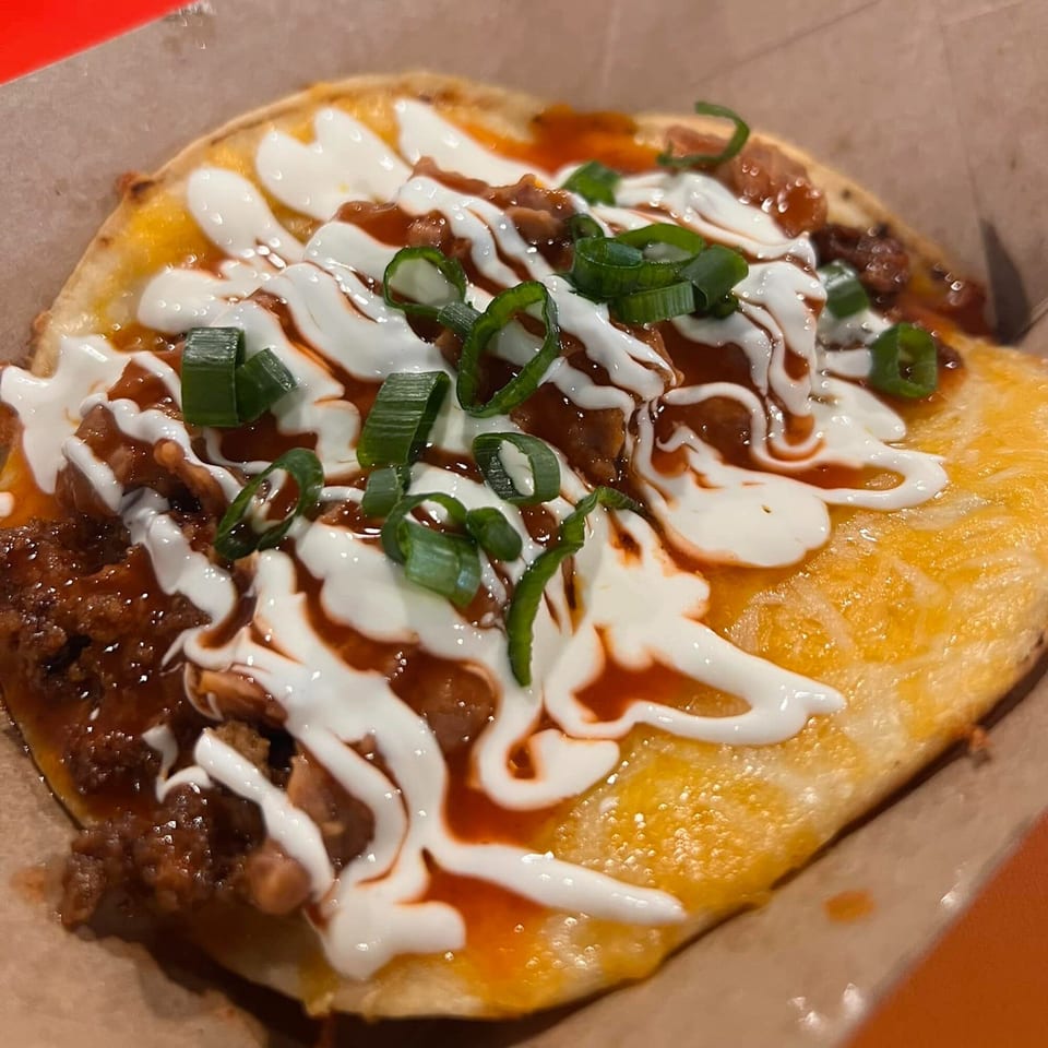Krazy Taco 937's taco with meat, cheese, sour cream, hot sauce, and green onions.