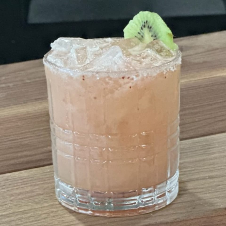 Krazy Taco 937's pink margarita with ice, a salted rim, and a kiwi slice garnish.